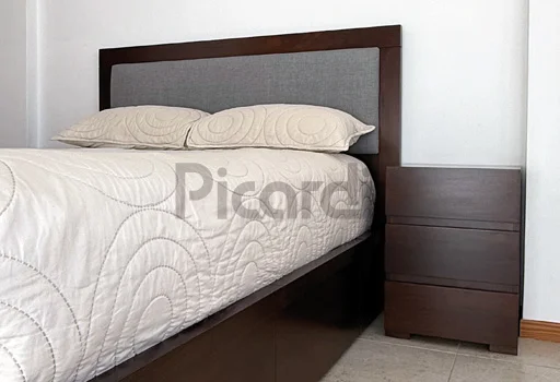 Dormitorio matrimonial moderno con respaldo tapizado y mesa de luz